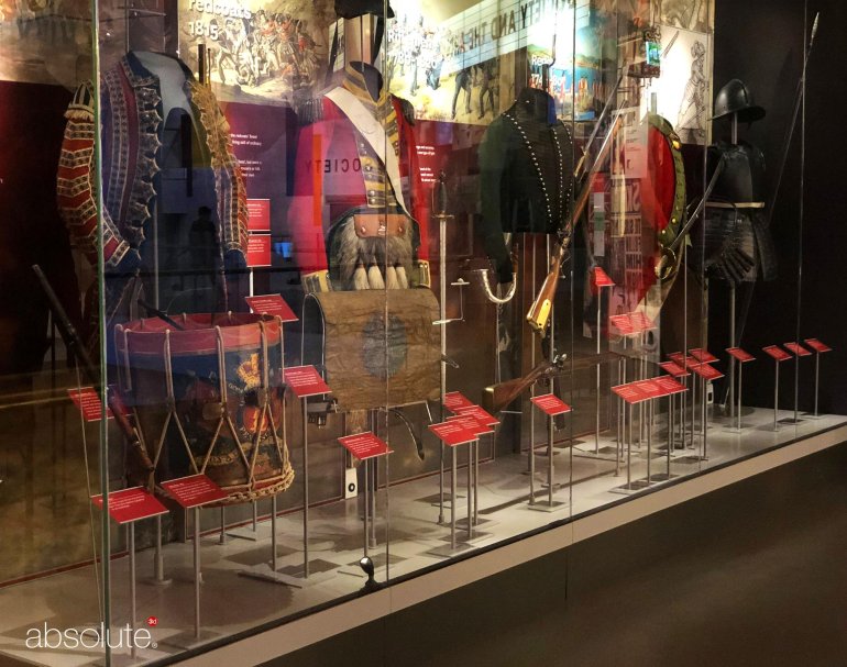 Uniforms showcased in a National Army Museum exhibition, with descriptive information displayed in pinnacle label holders. Uniforms showcased in a National Army Museum exhibition, with descriptive information displayed in pinnacle label holders.